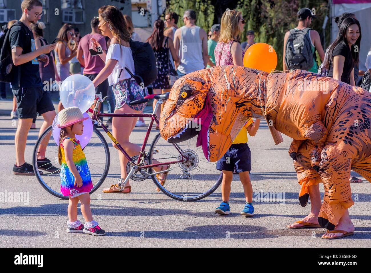 Kinder treffen auf Plastikawareness-Dinosaurier beim Khatsahlano Festival, Kitsilano, Vancouver, British Columbia, Kanada. Stockfoto