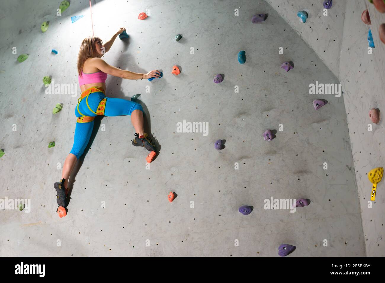 Schöne Klettererin Bouldern in der Kletterhalle. Extreme Sport und Indoor Climbing Konzept Stockfoto