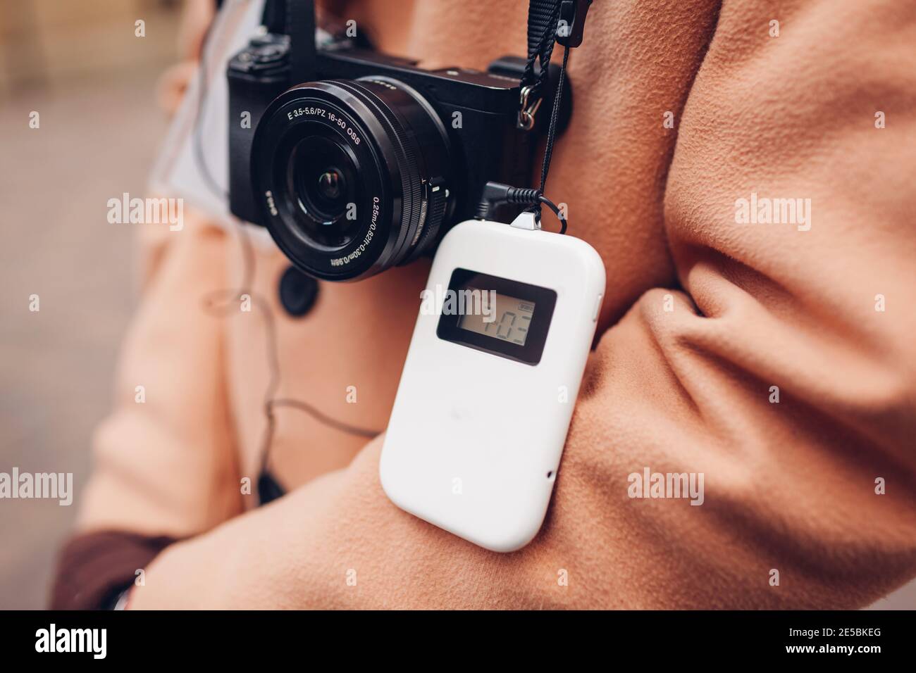 Tourist mit drahtlosen digitalen Audio-Tour-Guide-Ausrüstung mit Kopfhörern. Mann Reisende geht Sightseeing mit Kamera. Moderne Geräte für Ausflüge Stockfoto