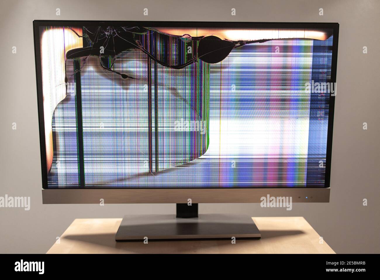 Computer führte Monitor auf einem Schreibtisch mit einem großen Riss Und bunte Linien, die über den Bildschirm laufen Stockfoto