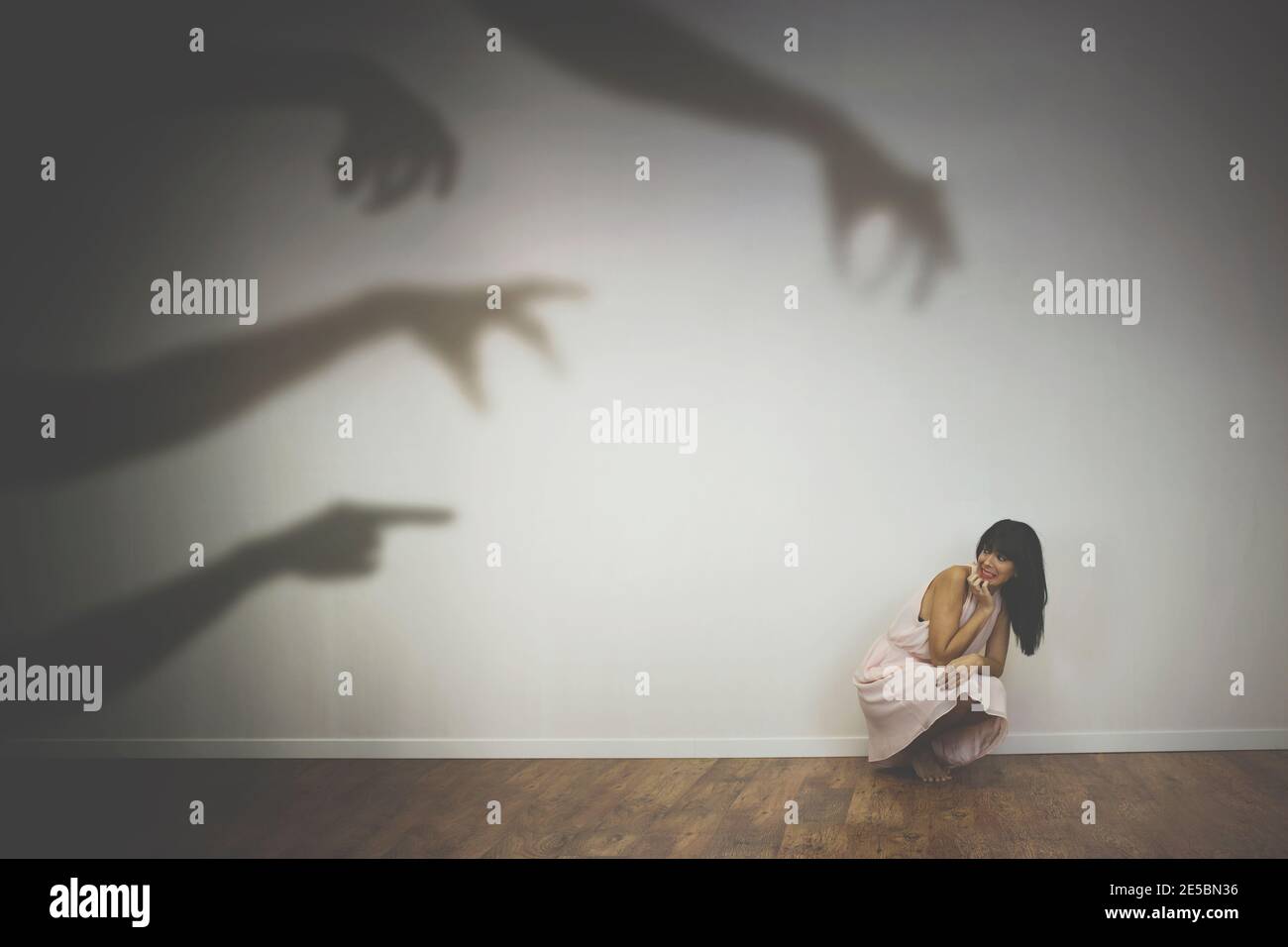 Frau erschreckt durch die Schatten der Hände von Dämonen Stockfoto