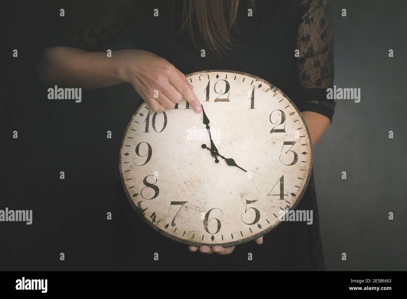 Person ändert die Zeit in seiner Uhr, Steuerungskonzept Stockfoto
