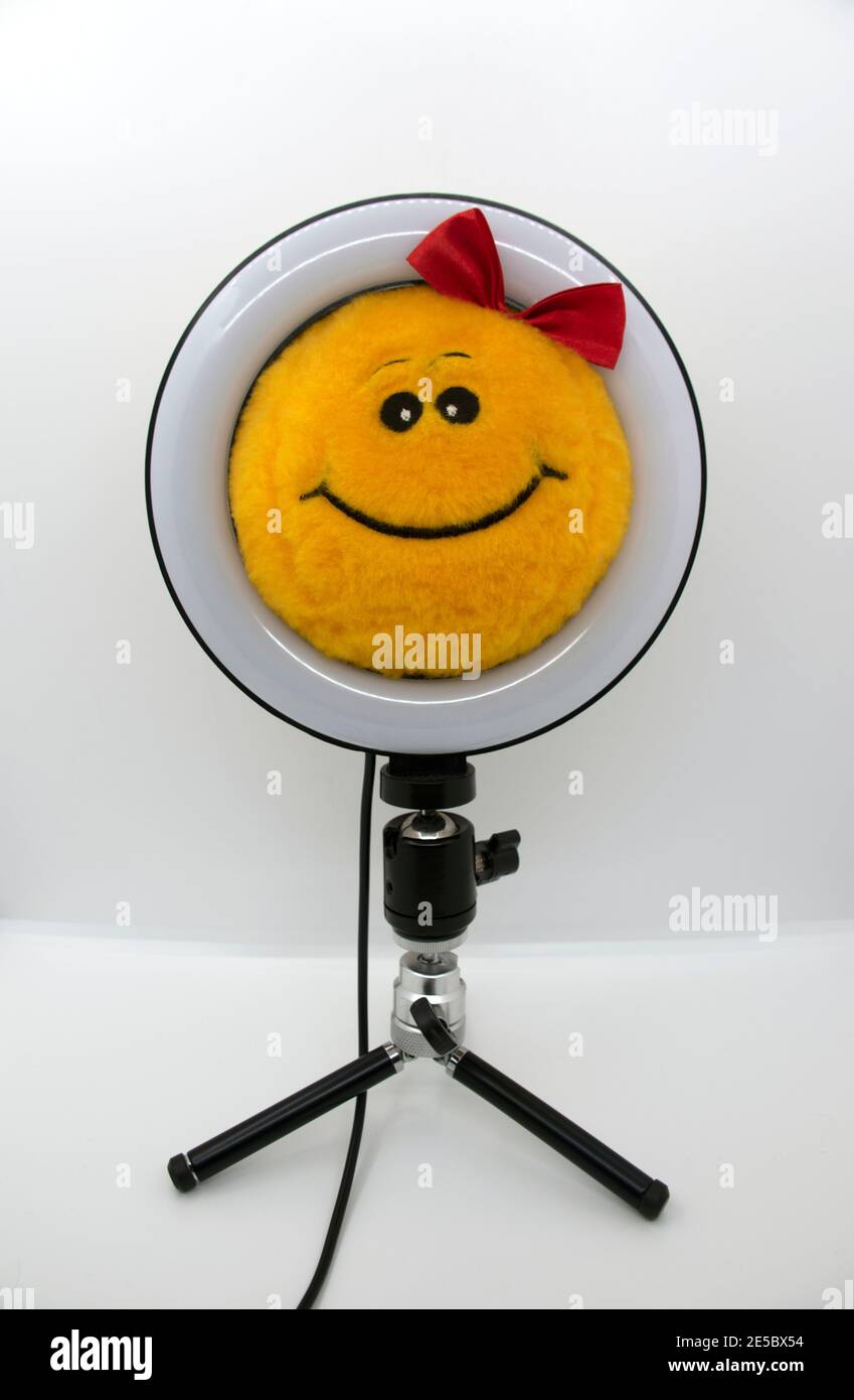 Smiley gelbes Plüschtier mit roter Schleife in einer Ringlampe. Stockfoto