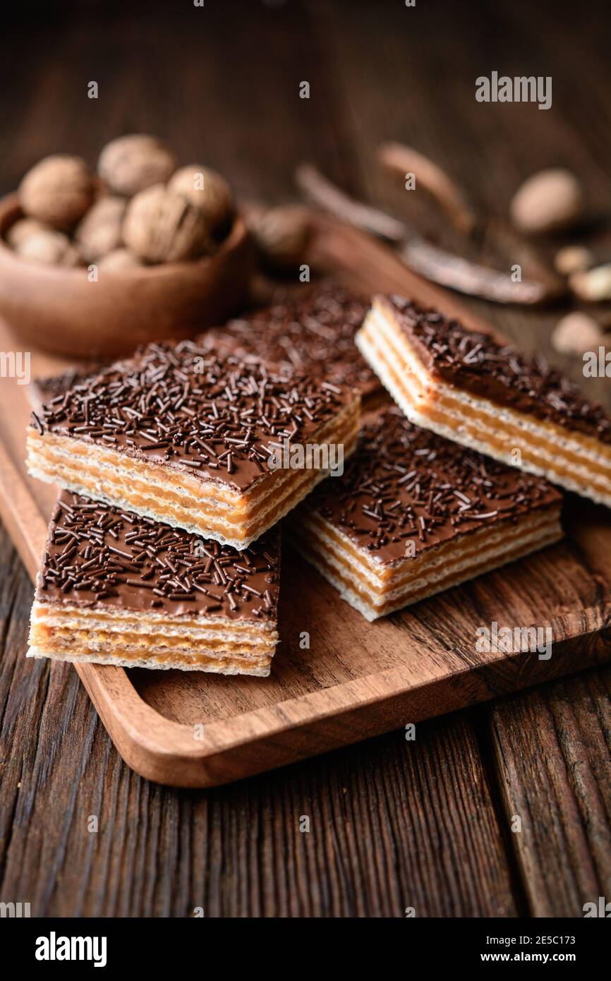 Hausgemachte süße Waffel mit Walnuss Toffee Füllung gefüllt und gekrönt Mit Schokoladenfrosting auf Holzhintergrund Stockfoto