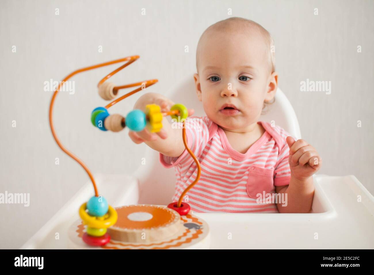 Kleines Mädchen spielt mit einem pädagogischen Labyrinth Spielzeug. Entwicklung von Feinmotorik und logischem Denken Stockfoto