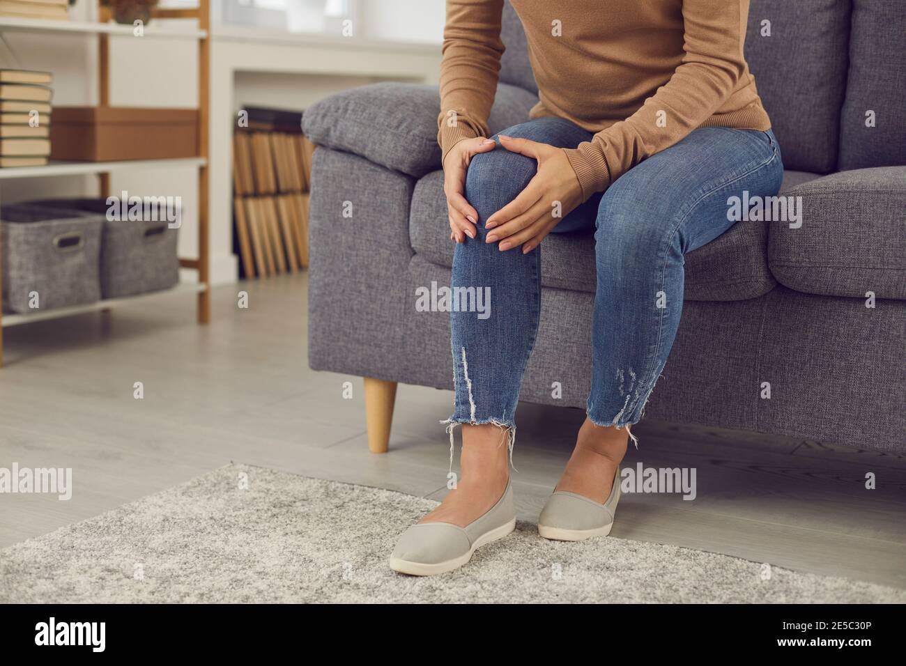 Frau, die rheumatische Störung hat oder Knie verletzt hat Hausunfall massiert ihre Kniekappe Stockfoto