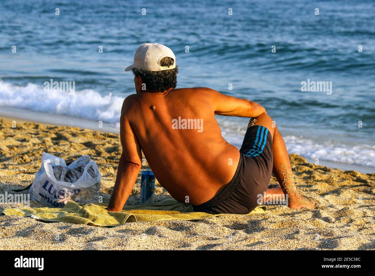 Einheimischer, der sich in der Abendsonne am Damlataş Strand in Alanya, Türkei sonnt Stockfoto