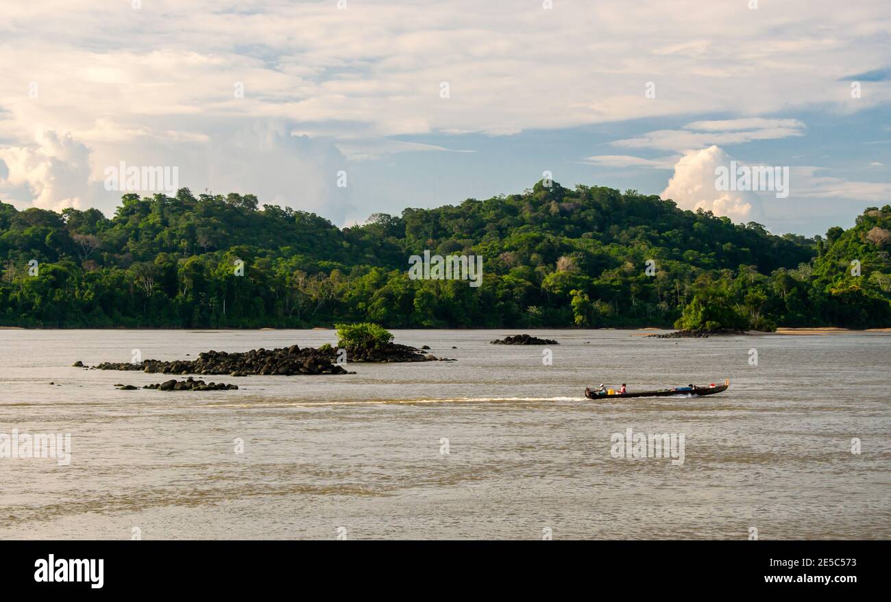 Mann segelt auf einem tropischen Fluss auf einem traditionellen Boot Stockfoto