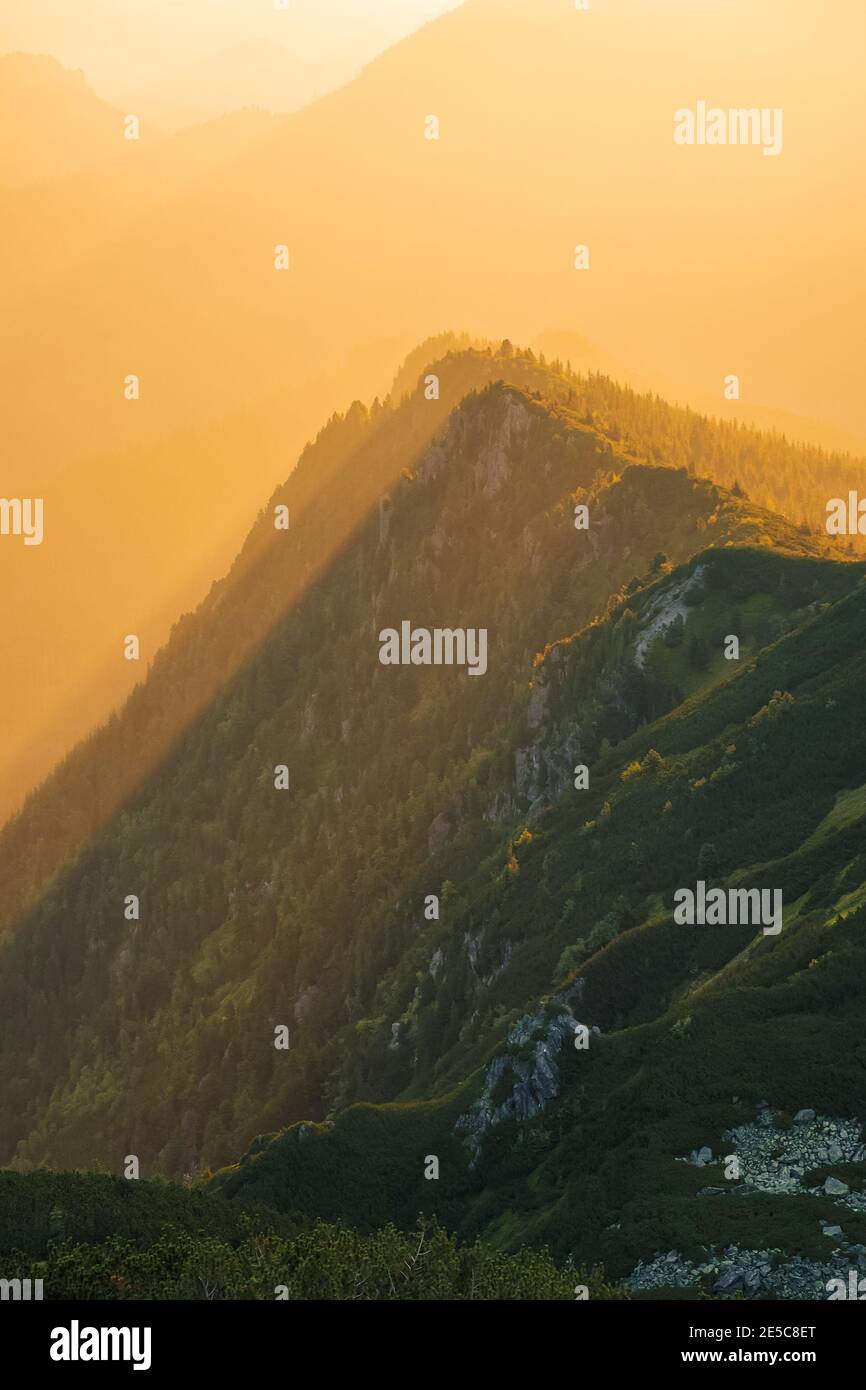 Majestätischer goldener Sonnenuntergang mit Sonnenstrahlen in großer Berglandschaft. Nationalpark hohe Tatra, Polen Stockfoto
