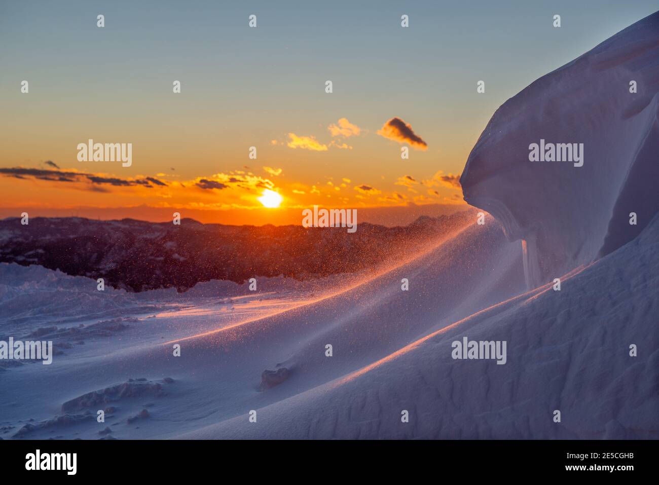 Schneesturm hoch in den Bergen bei Sonnenuntergang Stockfoto