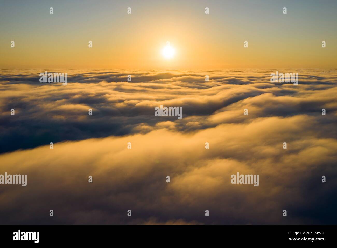 Beeindruckende Luftaufnahme des Sonnenuntergangs Himmel mit den Wolken unter uns. Die Schatten, die von der Sonne durch die Wolken projiziert werden, schaffen ein dramatisches lan Stockfoto