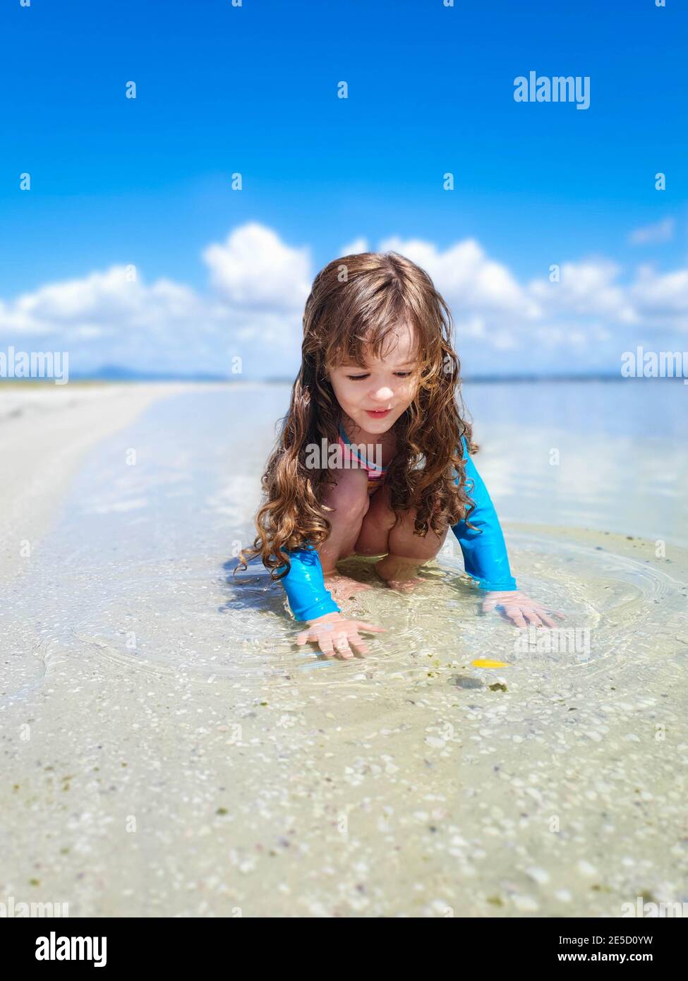 Mädchen spielt in seichtem Wasser am Strand, Rio de Janeiro, Brasilien Stockfoto