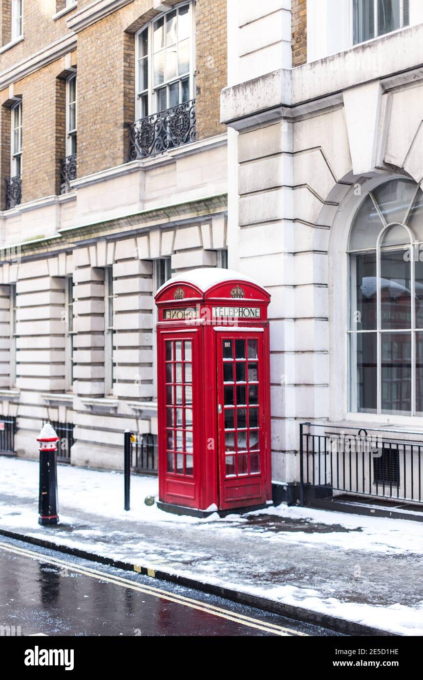Rote Telefondose im Schnee, London, England, Großbritannien Stockfoto