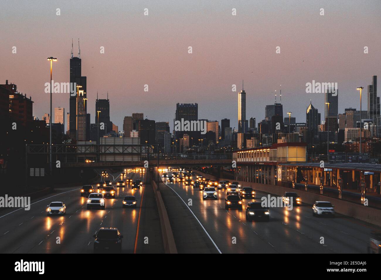 Skyline der Stadt und Autos auf der Autobahn bei Sonnenuntergang, Chicago, Illinois, USA Stockfoto