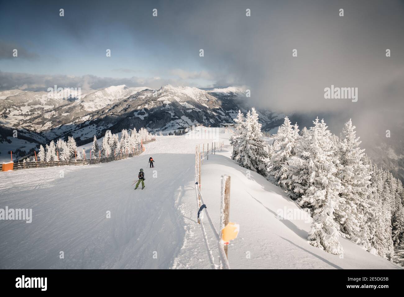 Rückansicht von zwei Skifahrern, die einen Berg hinunter fahren, Zell am See, Salzburg, Österreich Stockfoto