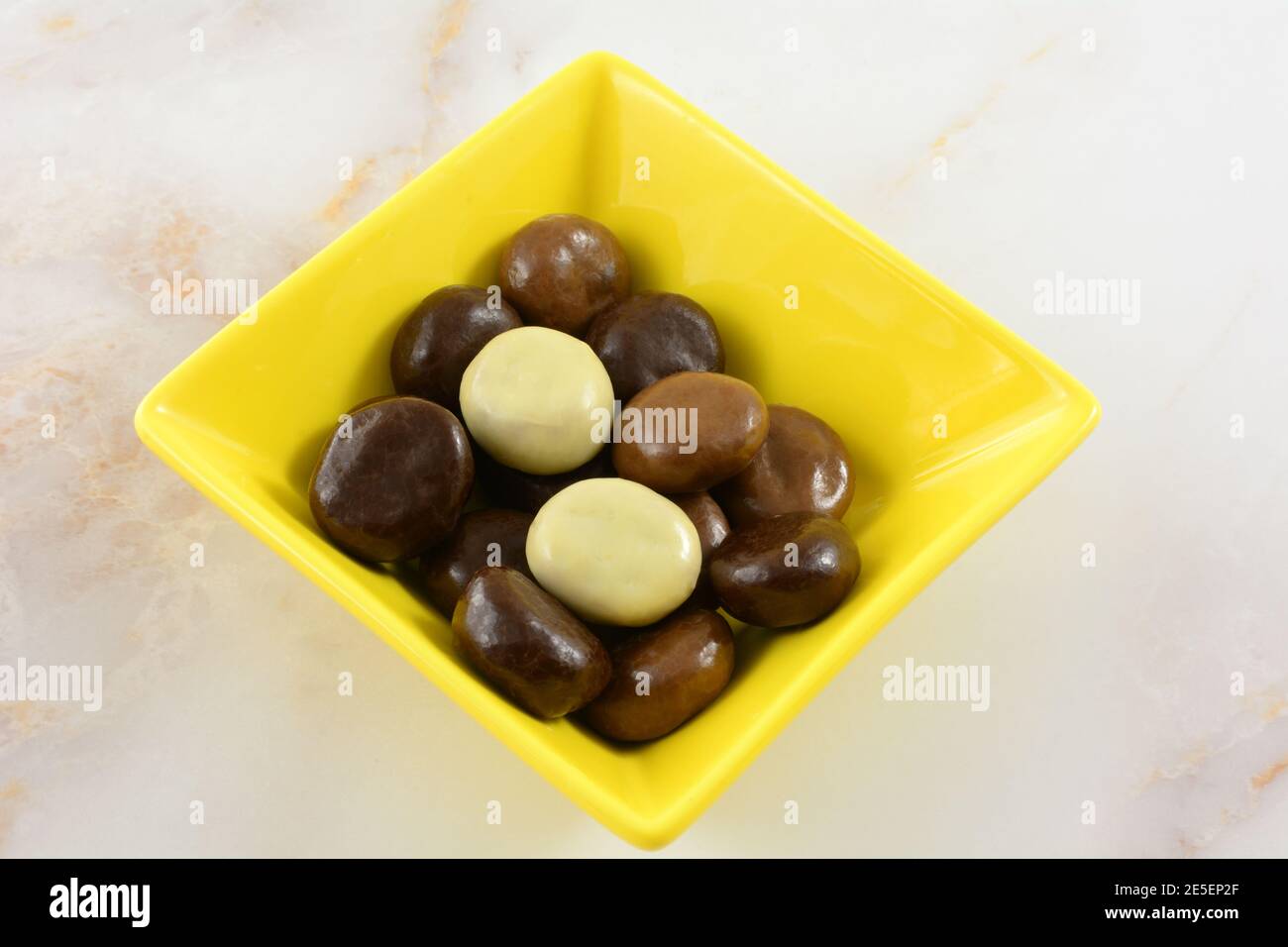 Kruidnoten Cookies mit einer Vielzahl von Milchschokolade, dunkle Schokolade und weiße Schokolade in gelben Snack-Schüssel auf dem Tisch bedeckt Stockfoto