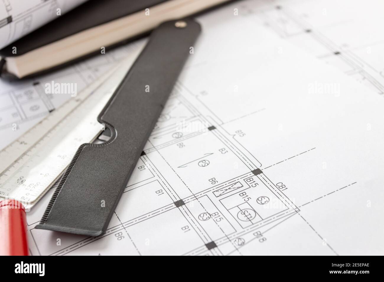 Rollen von Architekturentwürfen und Hausplänen auf dem Tisch und Architekten Zeichenwerkzeuge. Stockfoto
