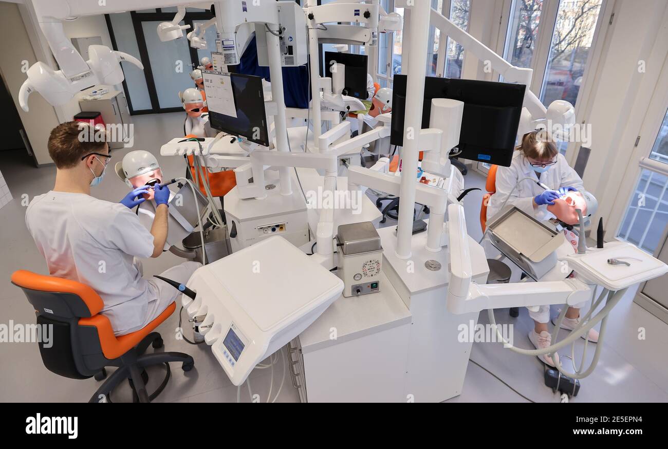 21. Januar 2021, Sachsen, Leipzig: Johann Dörschner (l.), Zahnstudent an der Universität Leipzig, praktiziert an einem "Phantompatienten" neben leeren Nachbarsitzen. Sie können nicht lernen, ein Zahnarzt online zu sein. Daher sollte die Ausbildung der 274 Zahnmedizinstudenten 'am Patienten' auch in der Corona-Krise möglich bleiben. Die Laborarbeit wurde verkleinert, die Kurse geviertelt und dann halbiert. Hygienekonzepte werden ständig an die Arbeit an echten Patienten angepasst. Schließlich müssen die angehenden Zahnärzte in der Lage sein, sicher eine Füllung zu machen oder eine Krone vorzubereiten. Foto: Jan Woitas/dpa-Zentralbil Stockfoto