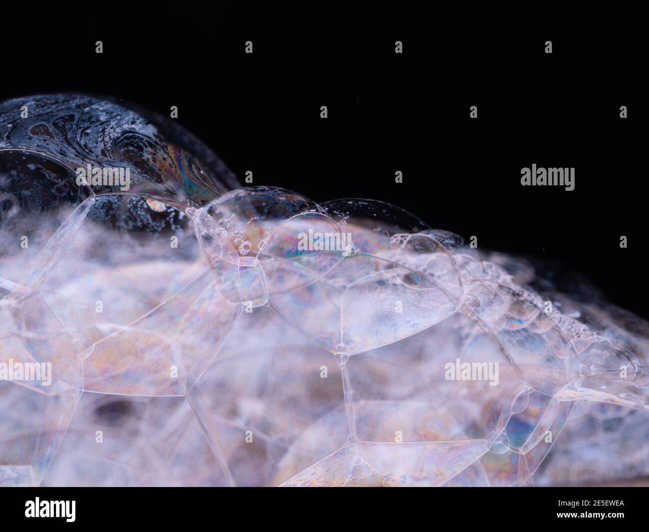 Seifenschaum mit Regenbogengradient. Abstrakter Hintergrund mit Seifenblasen Nahaufnahme. Makroaufnahme Stockfoto