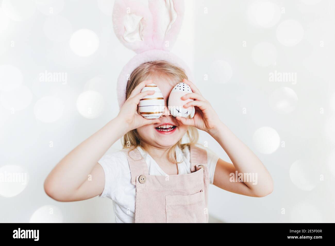 Kleines Mädchen mit Ostereiern und Hasenohren Hut Stockfoto