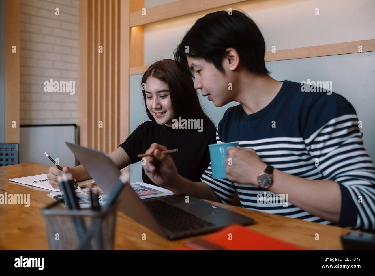 Gruppe von jungen Designern in legerer Kleidung ist mit einem Laptop, diskutieren Angelegenheiten. Stockfoto