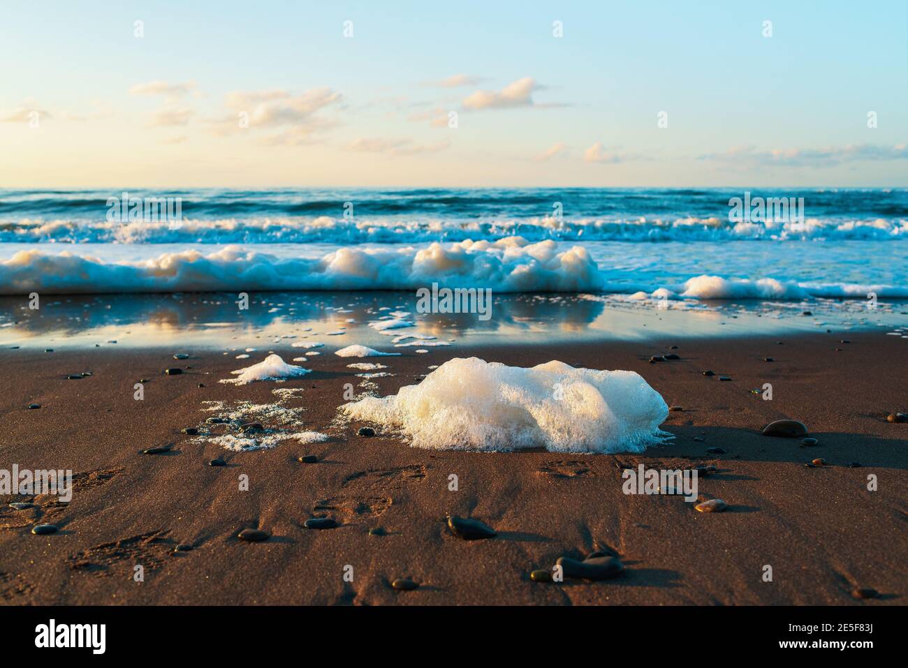 Wunderschönes Meer, Sandstrand, Meeresboden und klarer blauer Himmel bei Sonnenuntergang. Wilder Strand des Ochotsker Meeres, Insel Sachalin, Russland. Natürlicher Hintergrund. Stockfoto