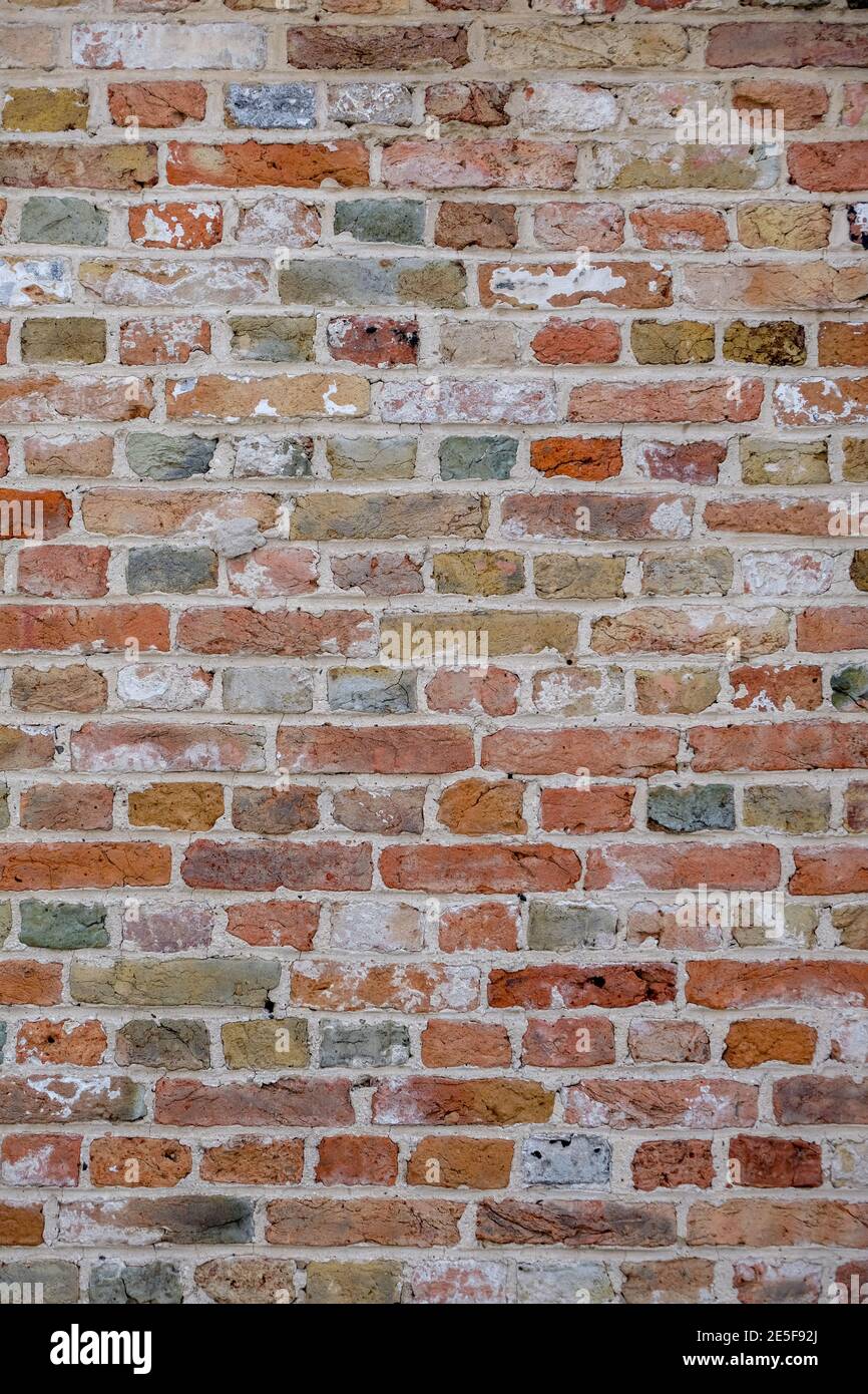 Backsteinmauer, Backsteinmauer mit bunt gefärbten Ziegeln, rot, grün, grau, braun im Sommer in Brügge, Belgien, rote Wandstruktur, als Hintergrund. Stockfoto