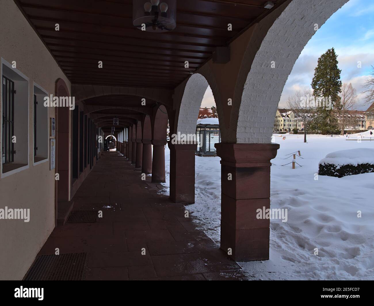 Historische Arkaden mit abnehmender Perspektive und verschneite Stadtplatz im Winter im touristischen Kurort Freudenstadt, Schwarzwald an sonnigen Tagen. Stockfoto