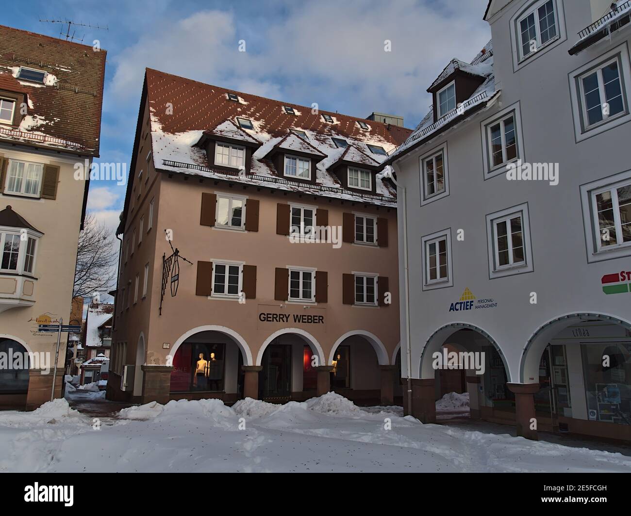 Ecke des historischen verschneiten Markts Freudenstadt, Schwarzwald mit alten Gebäuden, Arkaden und Geschäften einschließlich einer Gerry Weber Filiale. Stockfoto