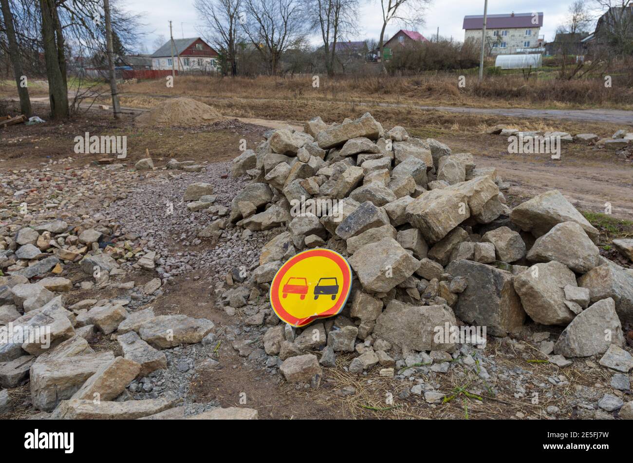 Gebogene weit verbreitete Straßenschild "No Overtaking" auf einem großen Haufen Von Felsen Stockfoto