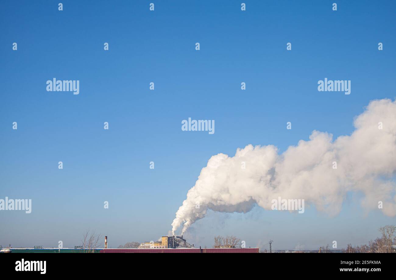 Weißer dichter Rauch aus dem Kamin des Kesselraums. Industriegebiet. Stockfoto