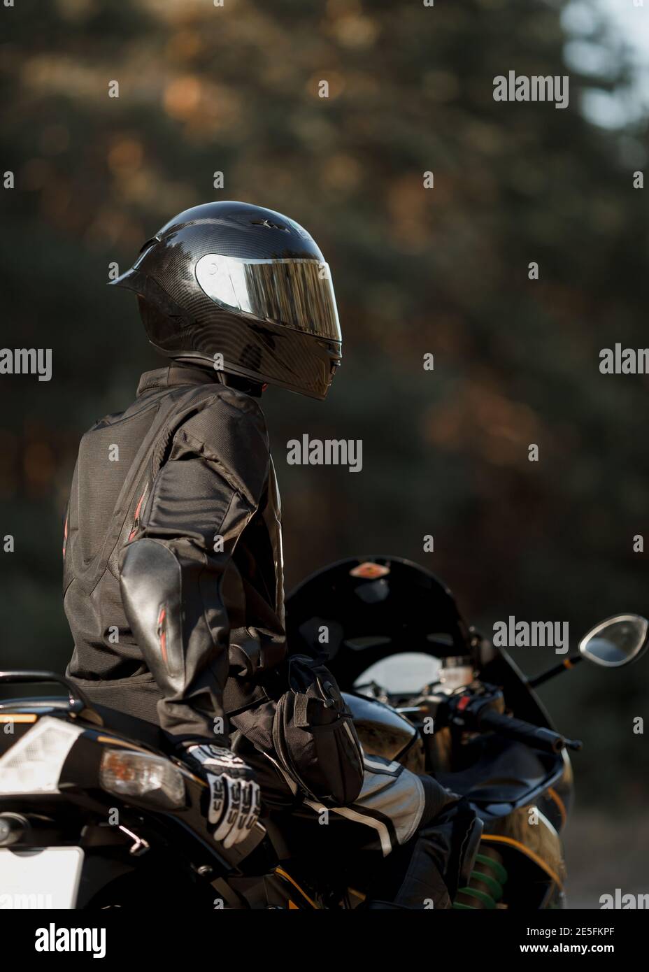 Biker in einem Helm und Leder Schutzausrüstung sitzt auf einem Motorrad, ein sportliches schnelles Motorrad Stockfoto