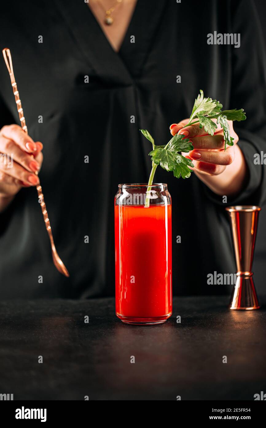 Frau macht blutigen mary Cocktail mit Sellerie Stockfoto