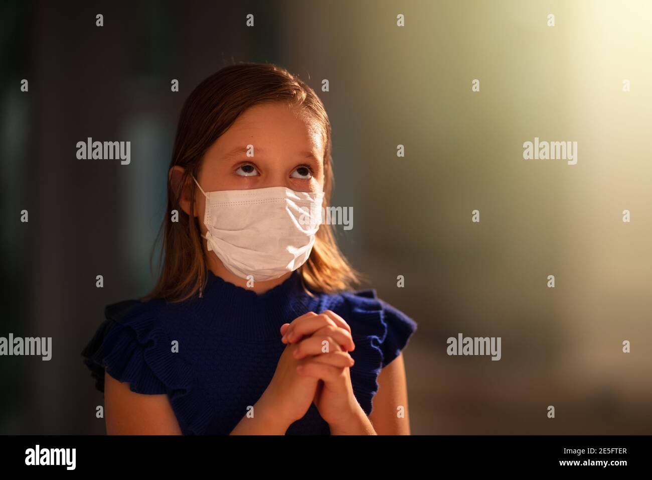 Betet für das Opfer des Coronavirus. Kind im Gesicht Maske beten für krank. Patient in Krankenhauskapelle oder Kirche während Covid-19 Ausbruch. Viruspandemie. Peopl Stockfoto