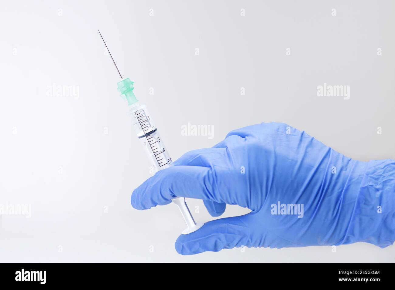 Hand in medizinischen Handschuh mit Spritze. Impfkonzept. Stockfoto