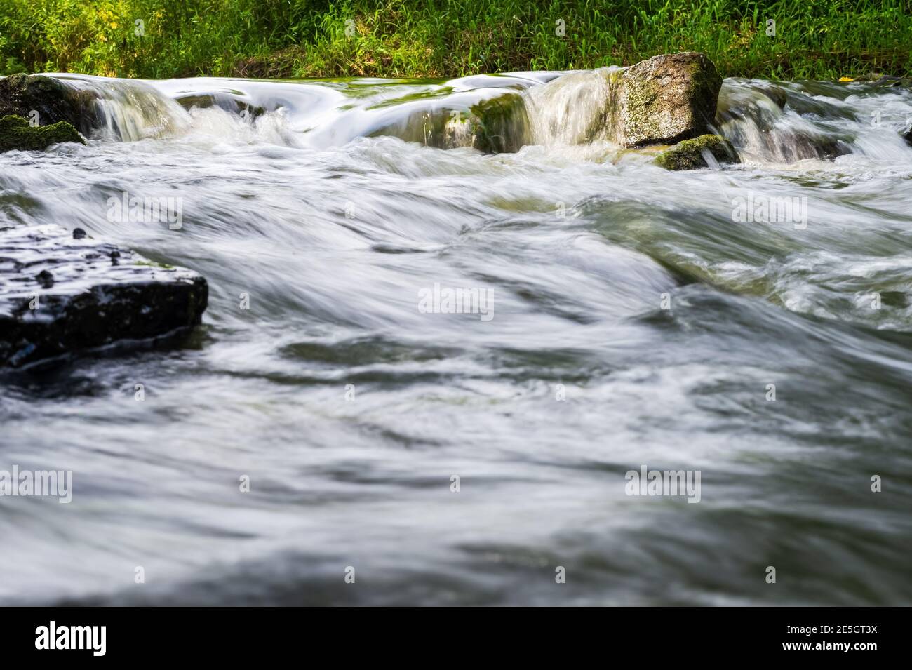 Fluss fließen über Felsen im Sommer Tag. Die Wellen des Flusses fließen. Entspannende Naturlandschaft Landschaft Stockfoto