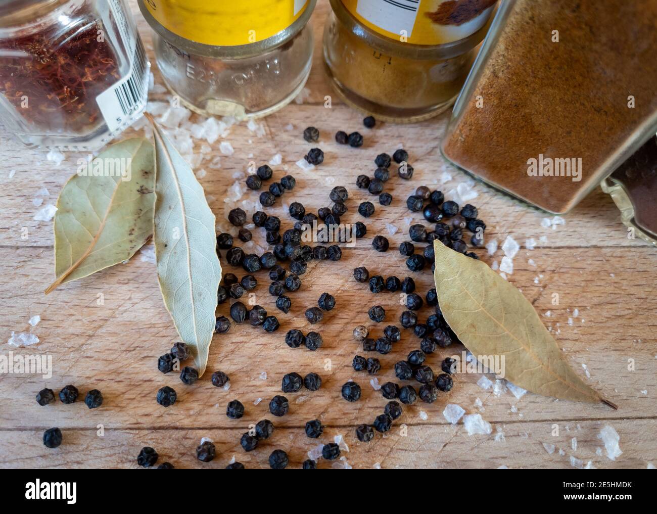 Eine Auswahl an Kochgewürzen auf einer Holzplatte. Stockfoto
