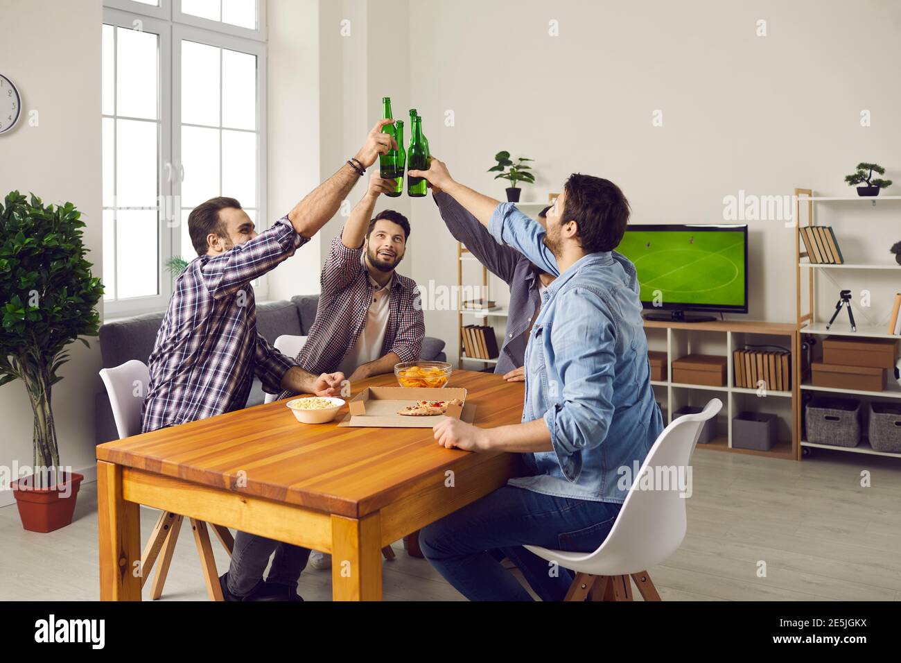 Eine Gruppe junger Freunde, die Bier trinken, Pizza essen und gemeinsam viel Vergnügen haben Stockfoto