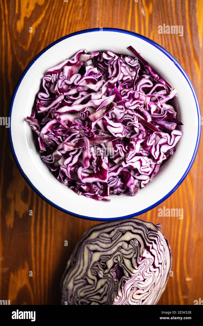 Frisch geschnittener Rotkohl in Schüssel auf Holztisch. Draufsicht. Stockfoto