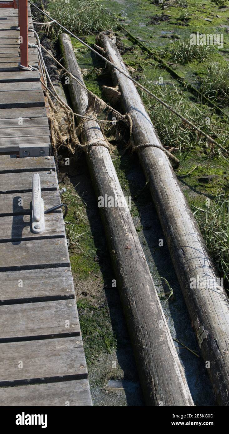 Telegraph Pole liegen neben einem hölzernen Steg Stockfoto