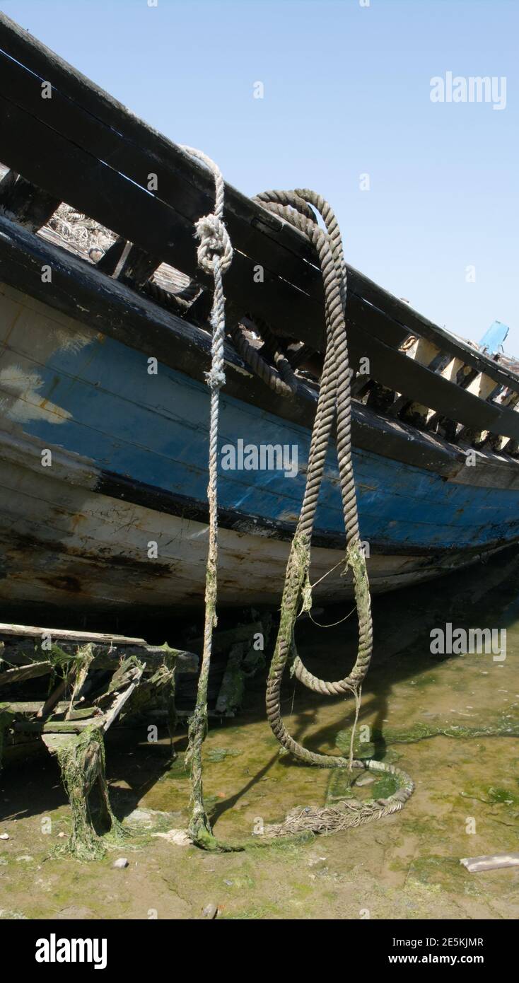 Seil drapierte über die Seite eines alten, verfaulten Bootes. Stockfoto