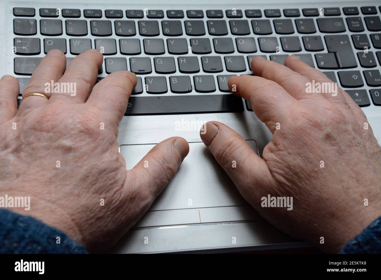 Hände eines älteren Mannes, der auf einem Laptop-Computer tippt Tastatur Stockfoto