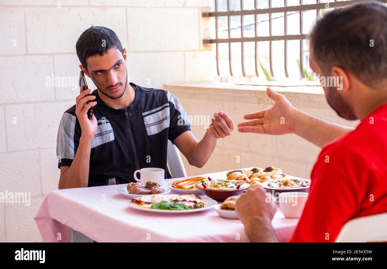 Der muslimische Mann und sein Freund essen zusammen Stockfoto