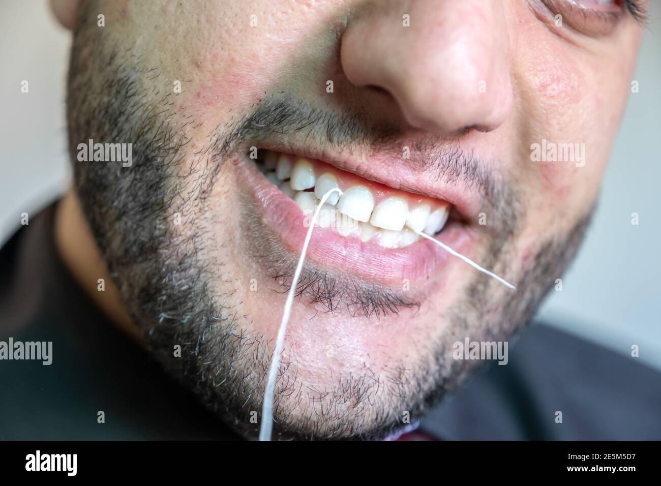 Muslimischer Mann verwendet Zahnseide Stockfoto