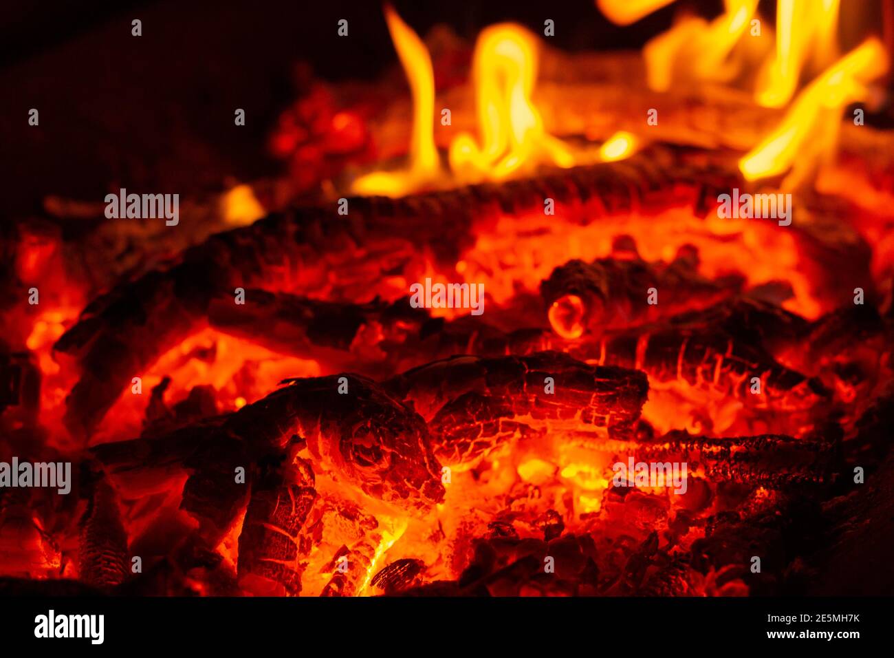 Feuerflamme von brennenden Kohlen im Lagerfeuer Stockfoto