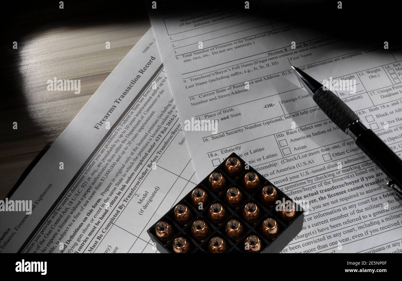 Public Domain Background Check Form für das FBI NICS System mit Munition und einem Stift auf der Oberseite. Stockfoto