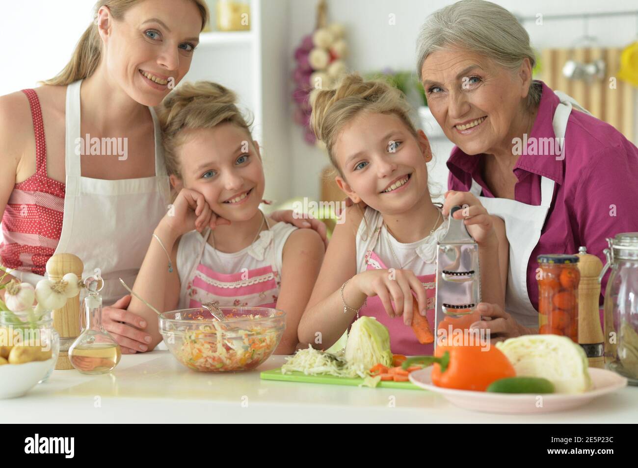 Nette Mädchen mit Mutter und Großmutter, die köstlichen frischen Salat Stockfoto