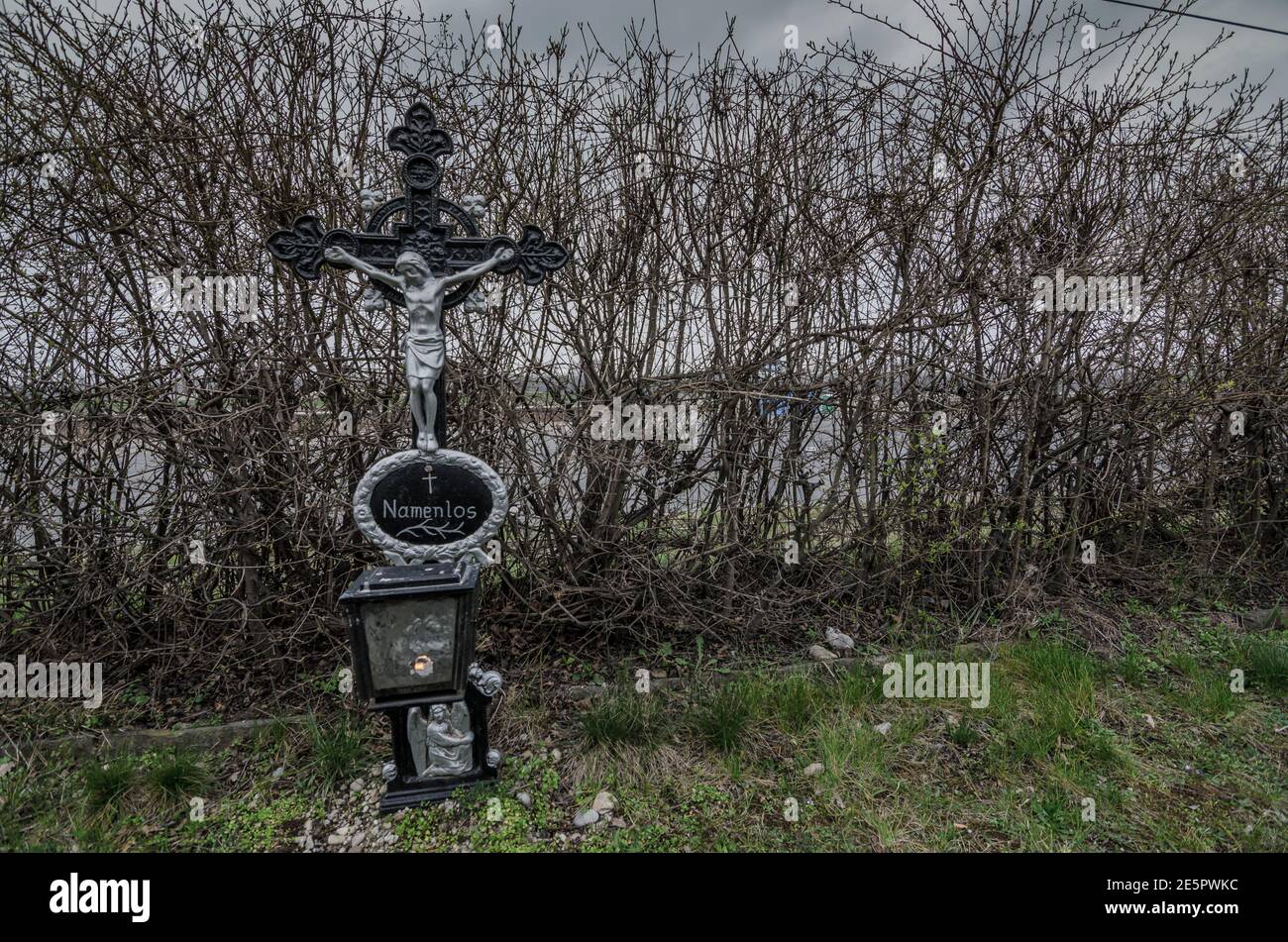 Eisenkreuz mit Inschrift auf namenlosem Friedhof Stockfoto