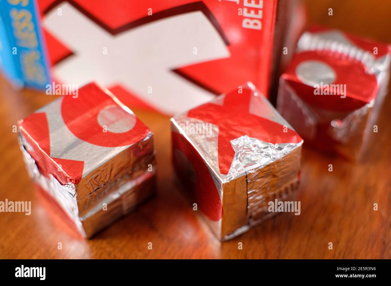 Oxo Würfel in Silberfolie verpackt auf Holztisch Oben Stockfoto