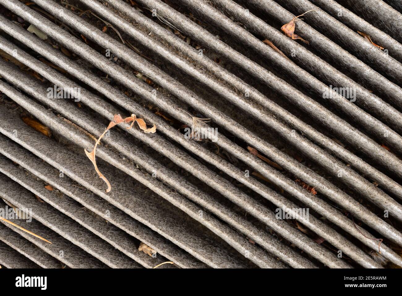 Verschmutzter Kabinenluftfilter in einem Winkel mit getrockneten Blättern und Schmutz. Stockfoto